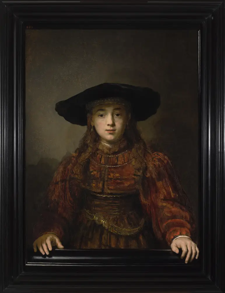 Rembrandtova slika z naslovom Dekle v okvirju, ki prikazuje deklico v rdeči žametni obleki in s črnim klobukom
